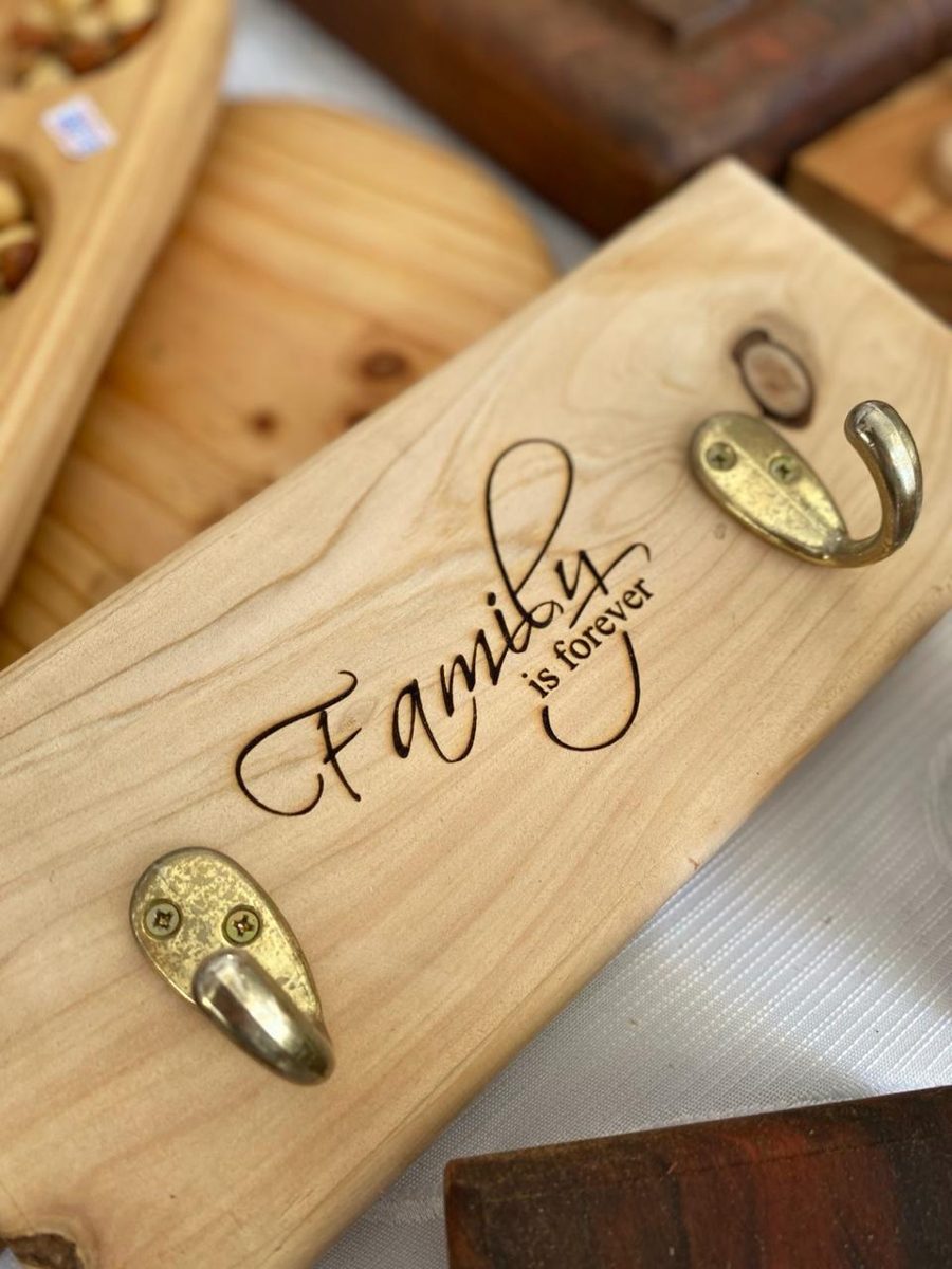 Colgador de madera con ganchos y la frase Family is forever